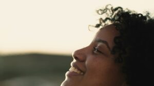 An African-American woman tilts her head back and smiles after receiving mental health treatment in NJ