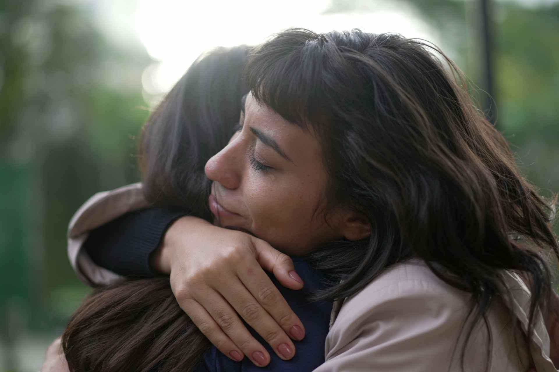 Family member sharing a supportive moment with an older loved one at home.